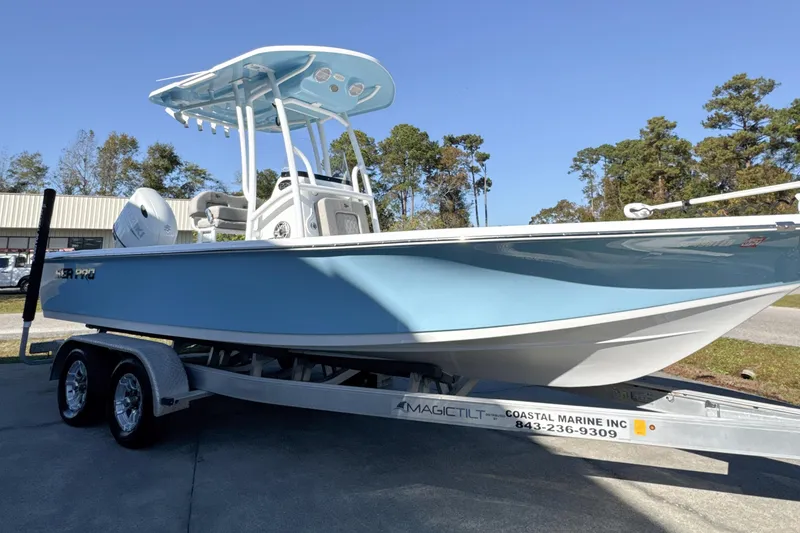 Slide: The Image of 2023 Sea Pro 228 Bay boat on trailer, light blue hull, parked outdoors. - 8