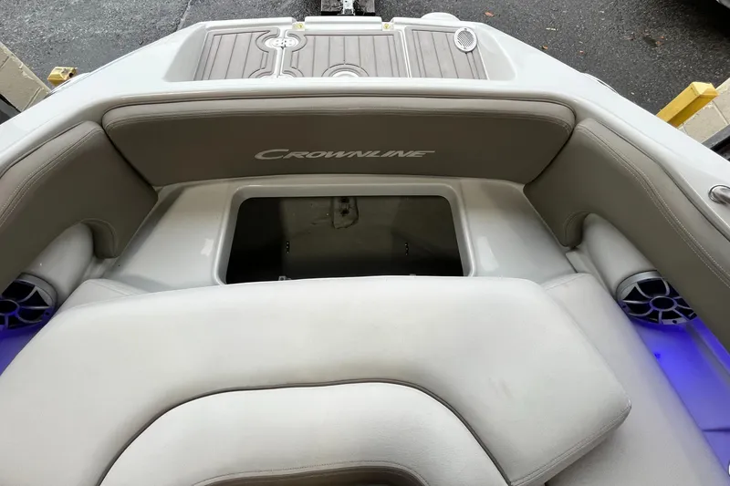 Slide: The Image of 2023 Crownline Eclipse E235 XS boat interior with cushioned seating and storage compartment. - 18