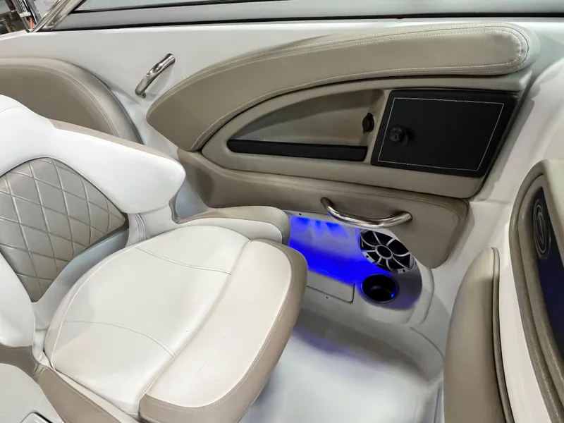 Slide: The Image of 2023 Crownline Eclipse E235 XS interior with beige and white seating, blue LED lighting. - 6