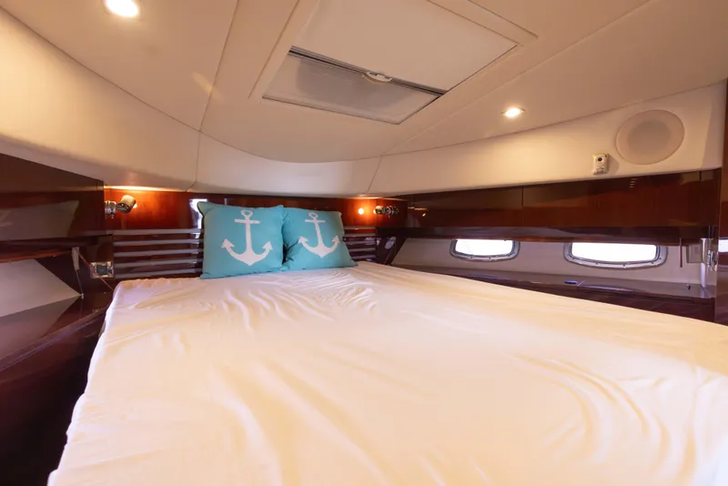 Slide: The Image of Luxurious bedroom interior of 2012 Sea Ray 450 Sedan yacht with anchor-themed pillows. - 19