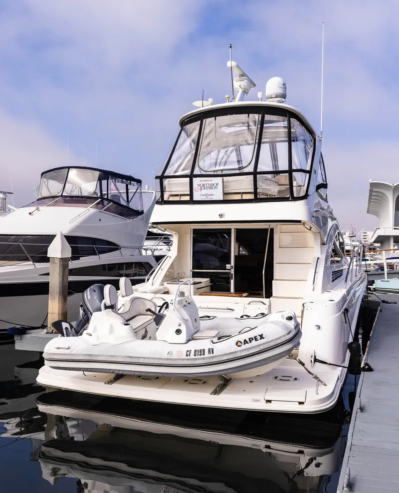 Slide: The Image of 2012 Sea Ray 450 Sedan yacht docked with inflatable boat on stern. - 2