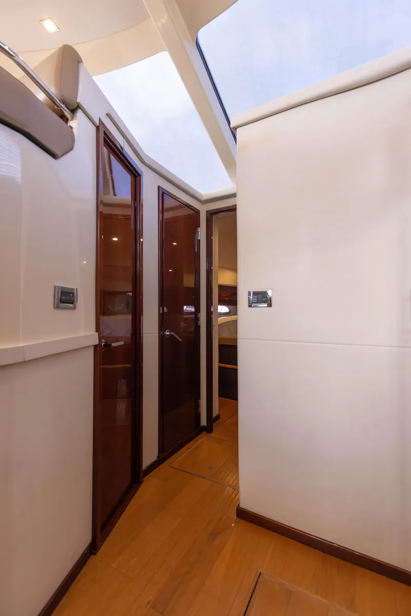 Slide: The Image of Interior hallway of 2012 Sea Ray 450 Sedan yacht with wooden doors and flooring. - 24