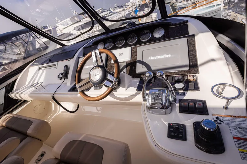 Slide: The Image of Interior cockpit of 2012 Sea Ray 450 Sedan with steering wheel and navigation controls. - 3