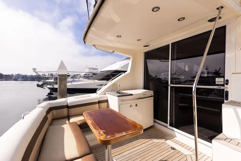 Slide: The Image of 2012 Sea Ray 450 Sedan yacht deck with seating and marina view. - 9