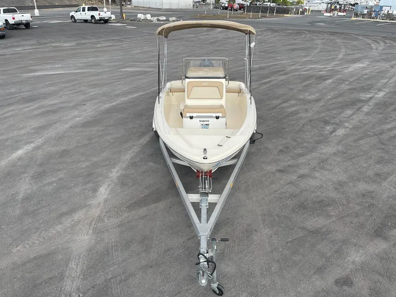 Slide: The Image of 2024 Scout 175 Sportfish boat on trailer in parking lot. - 2