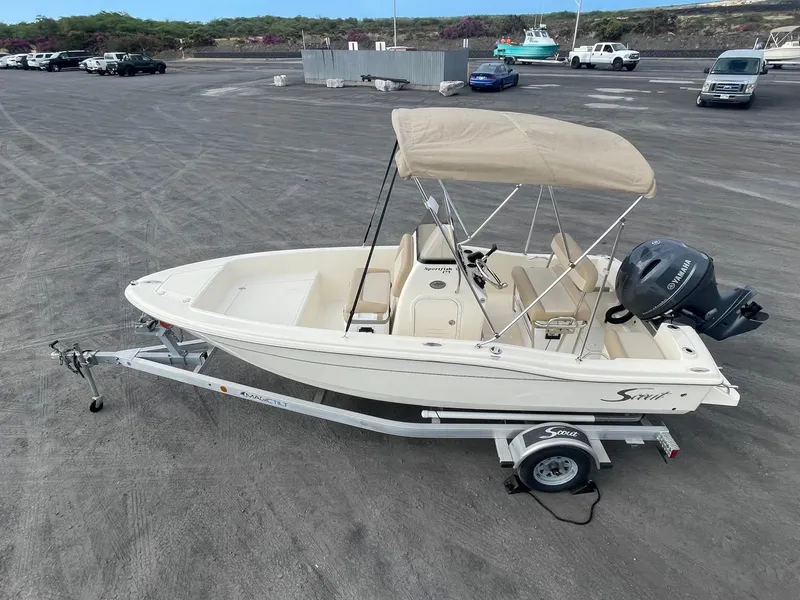 Slide: The Image of 2024 Scout 175 Sportfish boat on trailer with canopy, parked in a lot. - 4