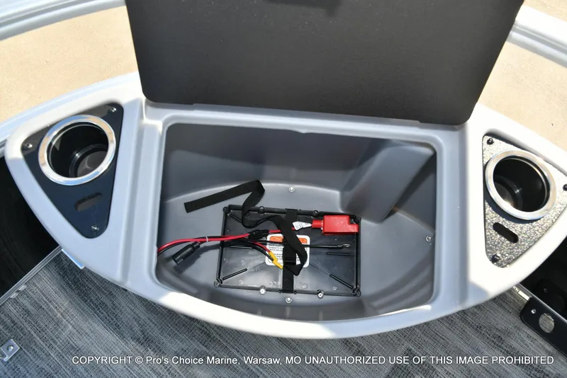 Slide: The Image of 2024 Ranger 220F boat storage compartment with cup holders and battery setup. - 34