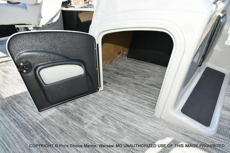 Slide: The Image of 2024 Ranger 220F boat interior storage compartment with open door, gray carpet flooring. - 46