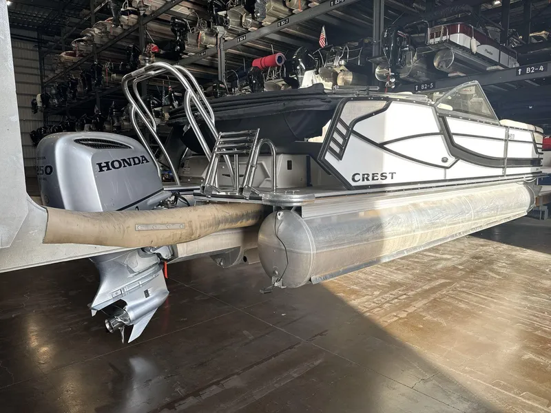 Slide: The Image of 2018 Crest Continental pontoon boat with Honda outboard motor in storage facility. - 6