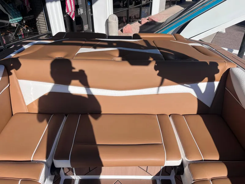Slide: The Image of 2025 Supreme S240 boat interior with tan and white seating, shadow of a person visible. - 10