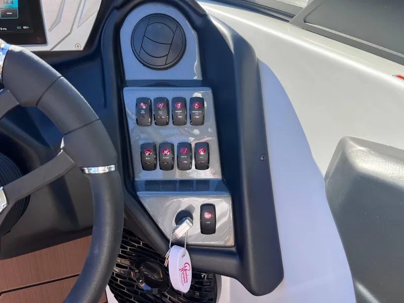Slide: The Image of 2025 Supreme S240 boat dashboard with control switches and steering wheel. - 9