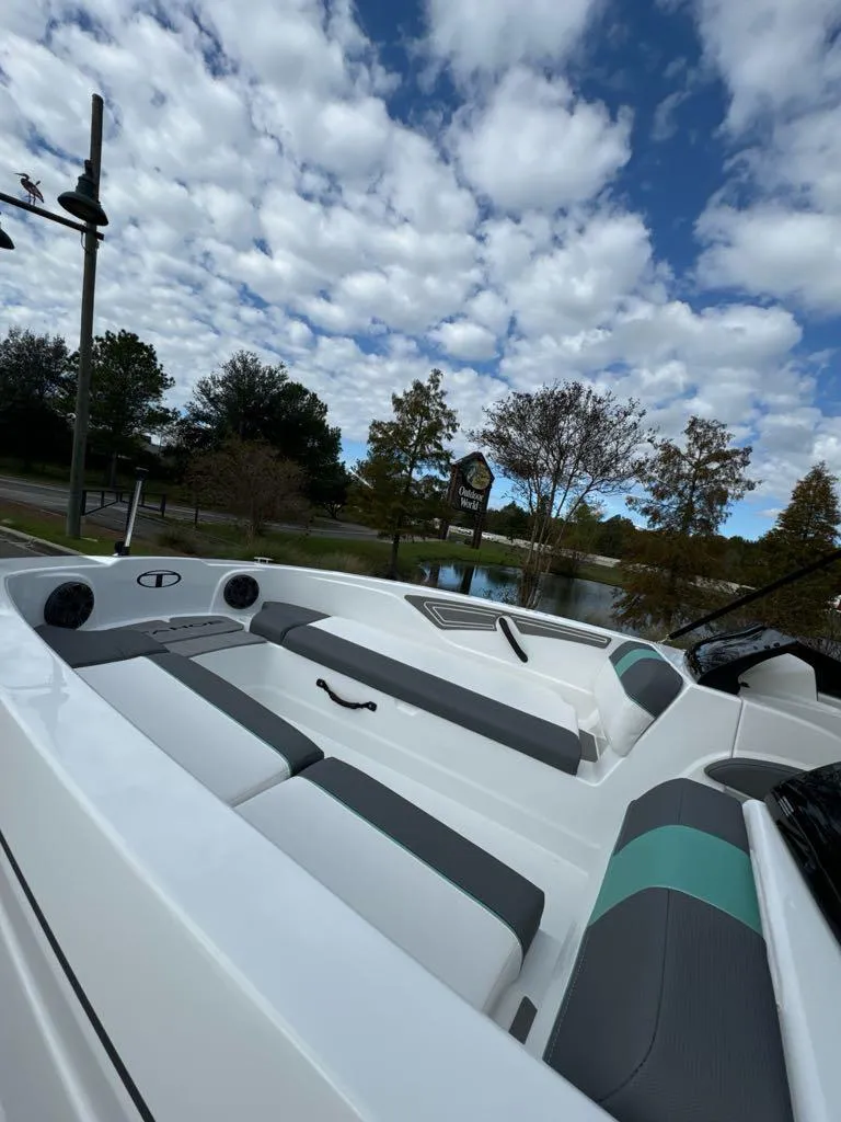 Slide: The Image of 2025 Tahoe T21 boat interior with sleek seating, under a partly cloudy sky. - 4