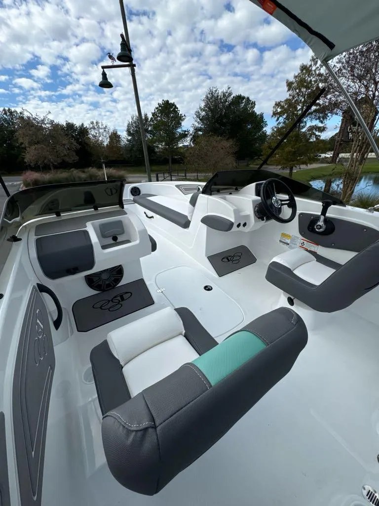 Slide: The Image of 2025 Tahoe T21 boat interior with modern seating and steering, under a partly cloudy sky. - 5