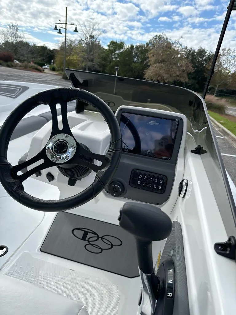 Slide: The Image of 2025 Tahoe T21 boat dashboard with steering wheel and control panel. - 8