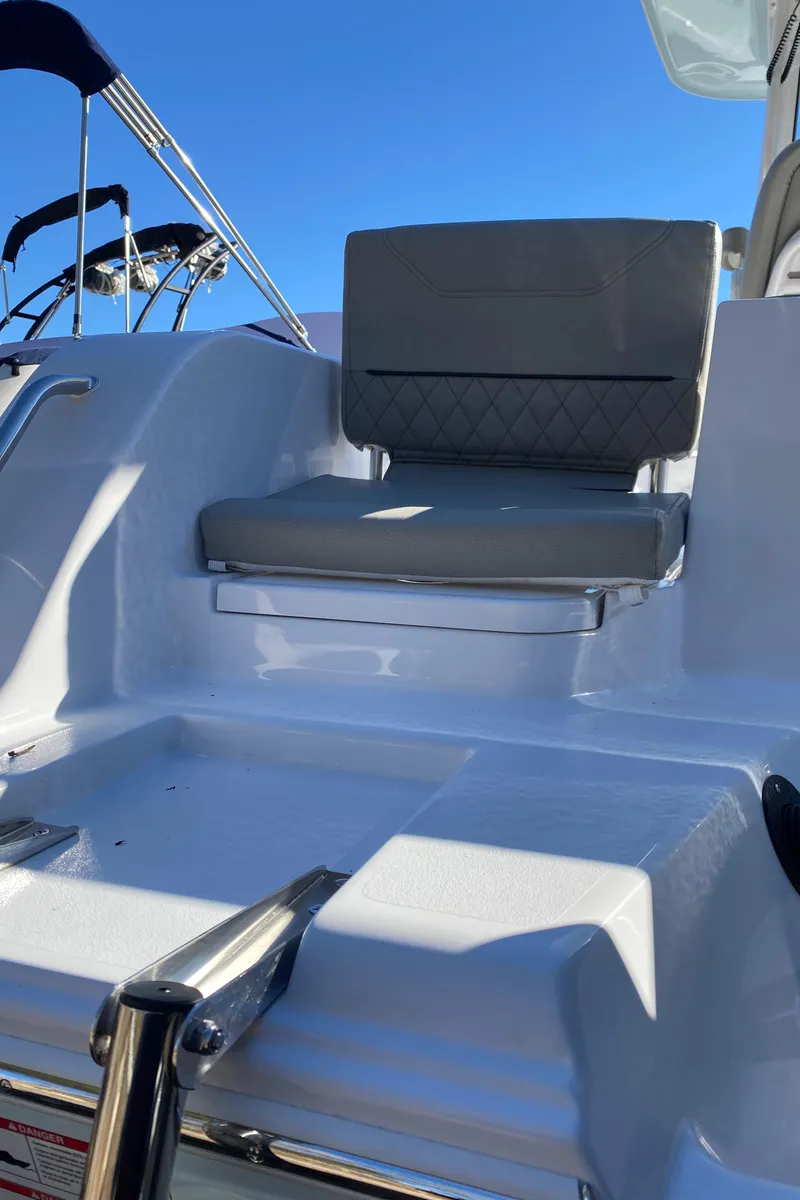 Slide: The Image of 2025 Sportsman Heritage 231 Center Console boat seat with gray cushion under clear blue sky. - 3