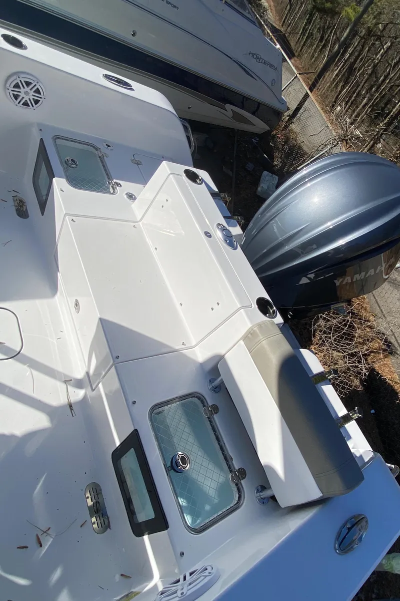 Slide: The Image of 2025 Sportsman Heritage 231 Center Console boat with Yamaha engine, docked outdoors. - 5