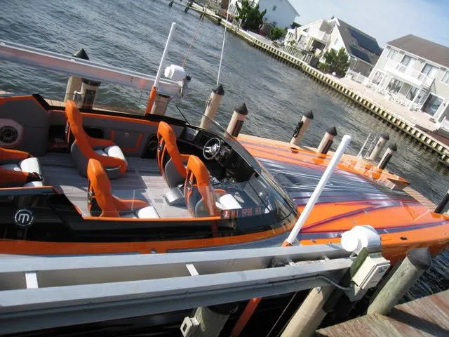 Slide: The Image of 2024 Mystic Powerboats C4000 docked, featuring sleek orange design and modern seating. - 12