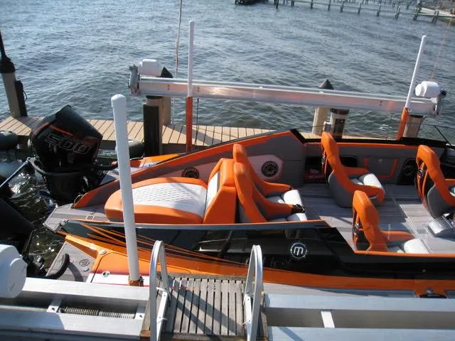Slide: The Image of 2024 Mystic Powerboats C4000 with vibrant orange seating, docked by the water. - 13