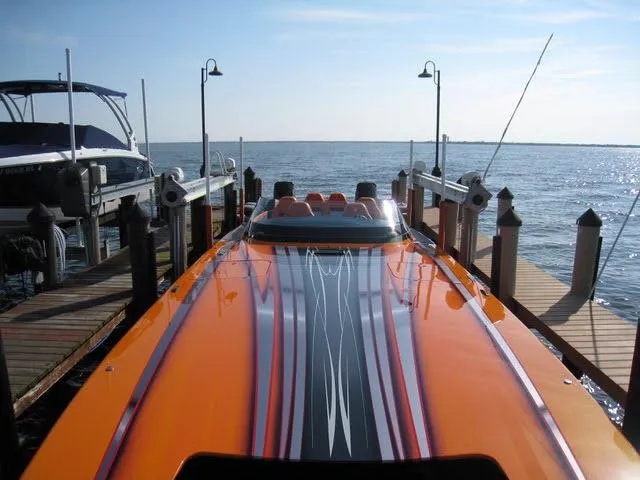 Slide: The Image of 2024 Mystic Powerboats C4000 in vibrant orange docked by the water. - 14