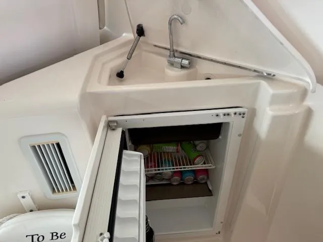 Slide: The Image of 2007 Tiara Yachts 4300 Sovran kitchenette with sink and mini fridge stocked with drinks. - 16