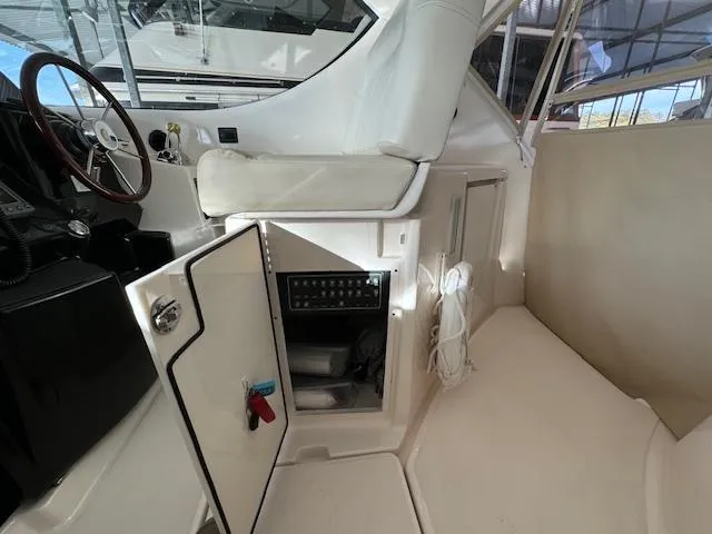 Slide: The Image of 2007 Tiara Yachts 4300 Sovran interior with open storage compartment and helm seat. - 17