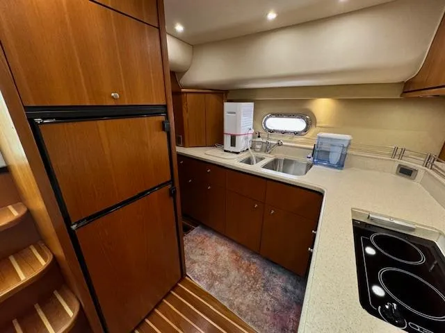 Slide: The Image of 2007 Tiara Yachts 4300 Sovran kitchen with wood cabinetry, sink, and appliances. - 46
