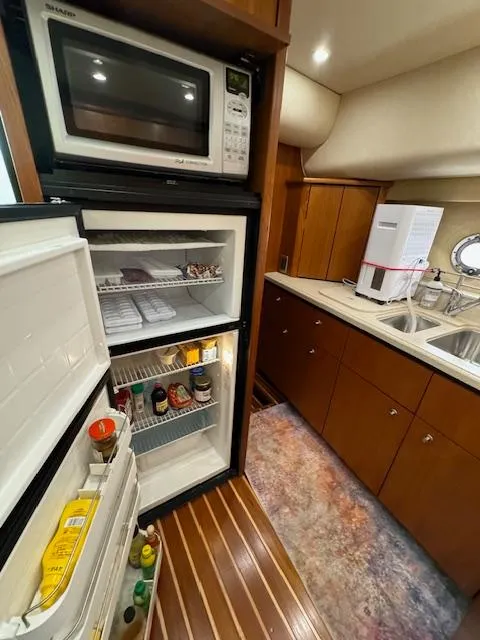 Slide: The Image of 2007 Tiara Yachts 4300 Sovran kitchen with fridge, microwave, and sink. - 47