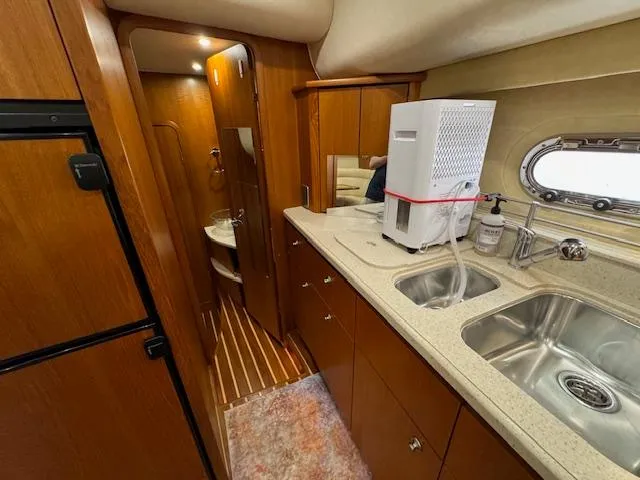 Slide: The Image of 2007 Tiara Yachts 4300 Sovran interior with kitchenette, sink, and wooden cabinetry. - 48