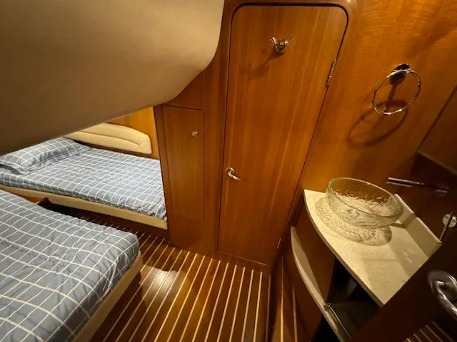 Slide: The Image of 2007 Tiara Yachts 4300 Sovran cabin with twin beds and wooden interior. - 49
