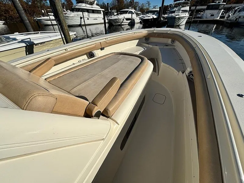 Slide: The Image of 2016 Scout 350 LXF boat interior with tan seating, docked in a marina. - 15