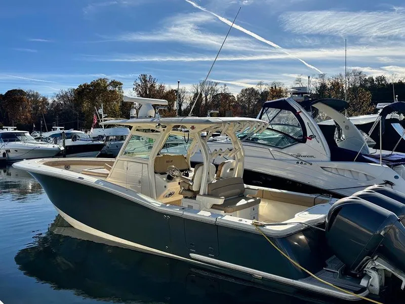 Slide: The Image of 2016 Scout 350 LXF boat docked in a marina under a clear sky. - 2