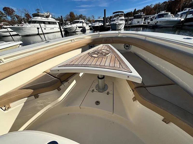 Slide: The Image of 2016 Scout 350 LXF boat interior with wooden table and seating, docked at marina. - 23