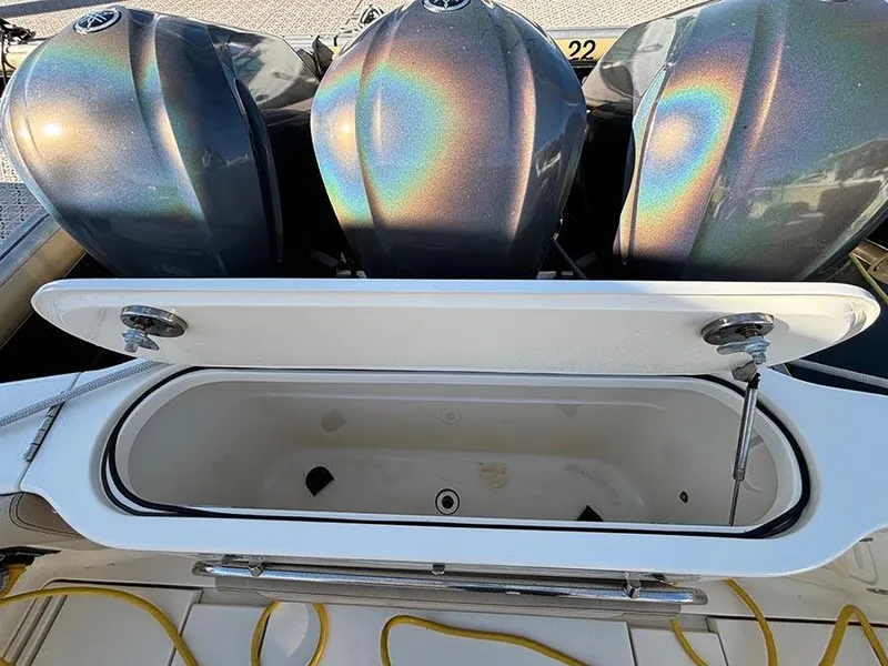 Slide: The Image of 2016 Scout 350 LXF boat with open storage compartment and triple outboard engines. - 35
