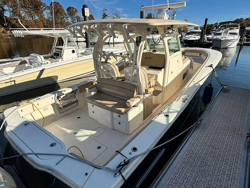 Slide: The Image of 2016 Scout 350 LXF boat docked at marina, featuring spacious seating and modern design. - 4