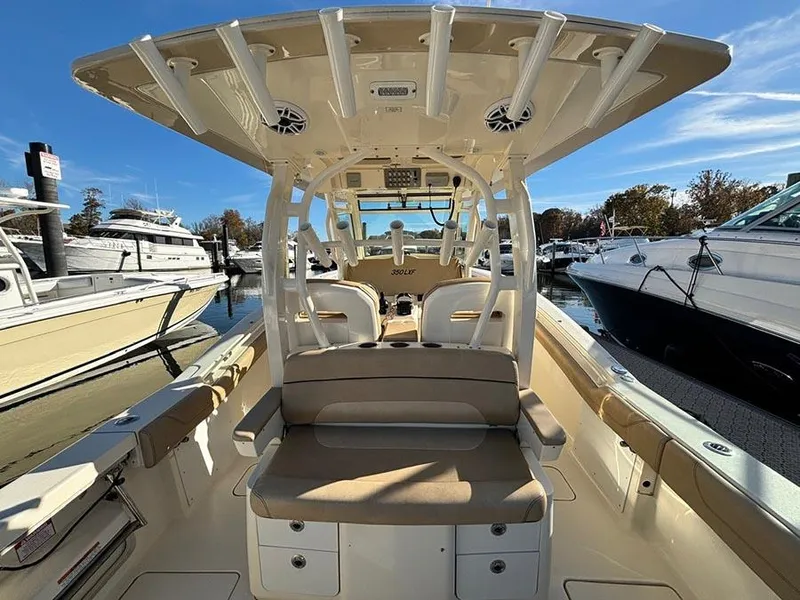Slide: The Image of 2016 Scout 350 LXF boat interior at marina, featuring seating and rod holders. - 6