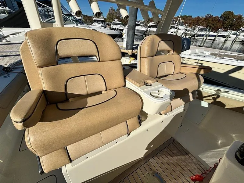 Slide: The Image of 2016 Scout 350 LXF boat interior with beige cushioned seats and cup holders. - 9