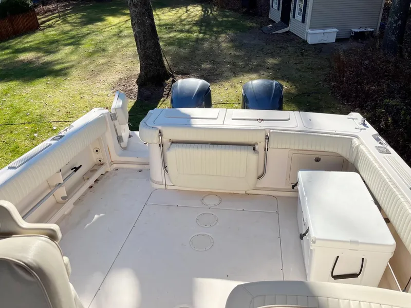 Slide: The Image of 2003 Grady-White 330 Express boat deck with seating and storage, parked outdoors. - 15