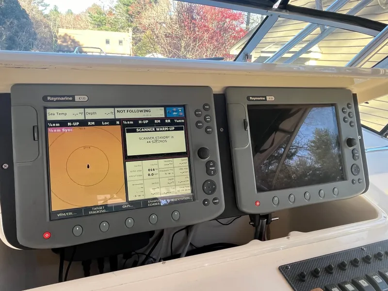 Slide: The Image of 2003 Grady-White 330 Express boat dashboard with dual Raymarine navigation displays. - 19