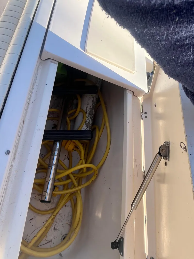 Slide: The Image of Open storage compartment on 2003 Grady-White 330 Express boat with yellow cables inside. - 26