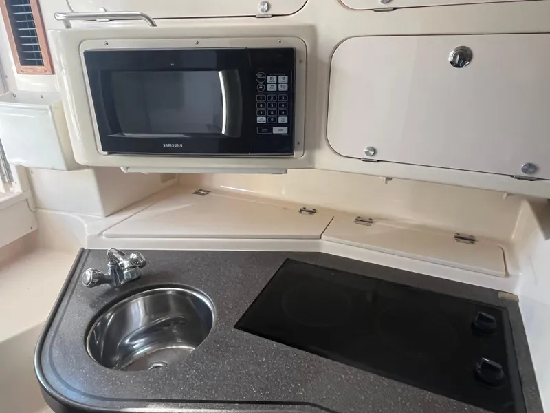 Slide: The Image of 2003 Grady-White 330 Express boat kitchen with microwave, sink, and stove. - 33