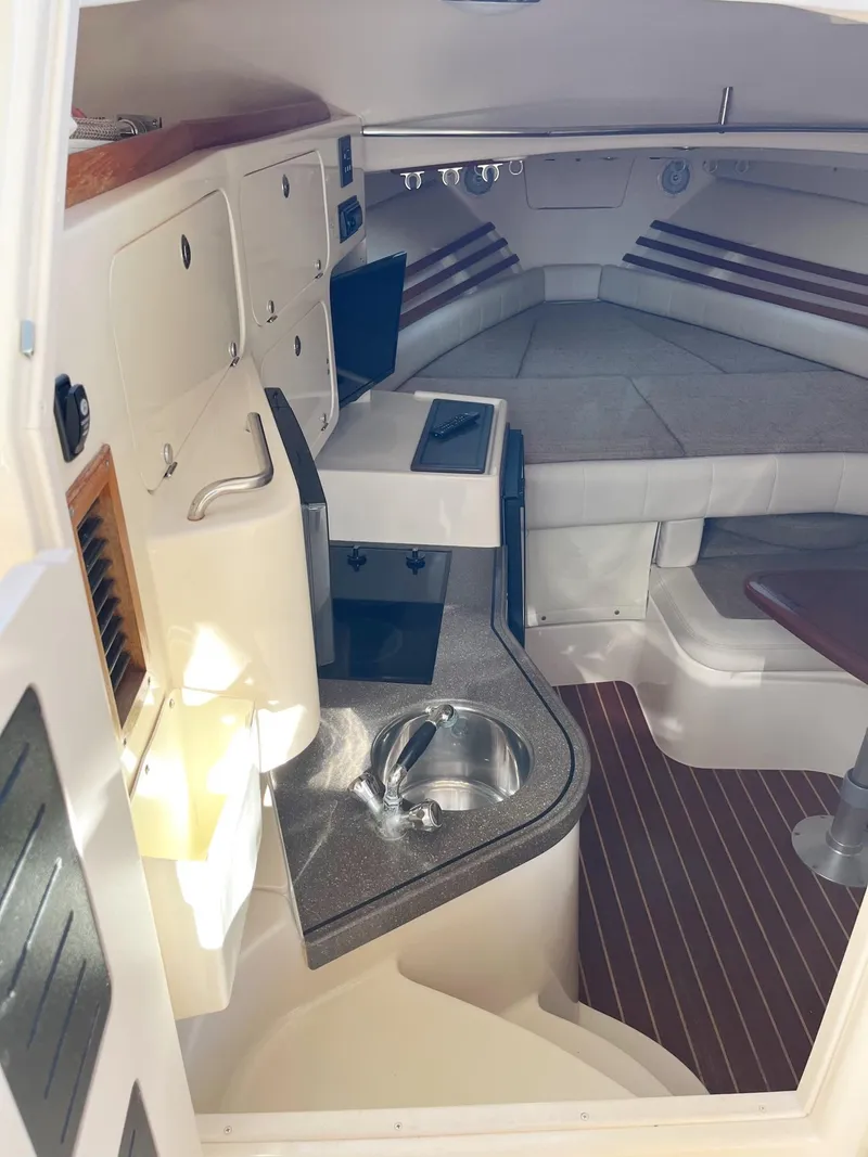 Slide: The Image of 2003 Grady-White 330 Express cabin interior with kitchenette and seating area. - 34
