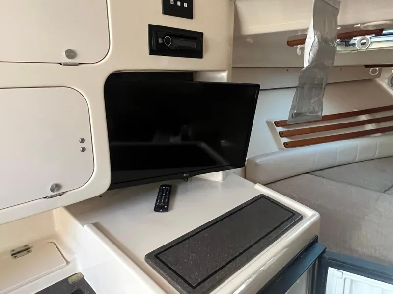 Slide: The Image of 2003 Grady-White 330 Express cabin interior with TV and storage cabinets. - 35