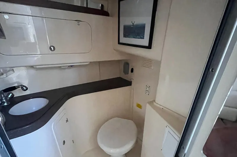 Slide: The Image of 2003 Grady-White 330 Express boat bathroom with sink, toilet, and storage cabinets. - 44