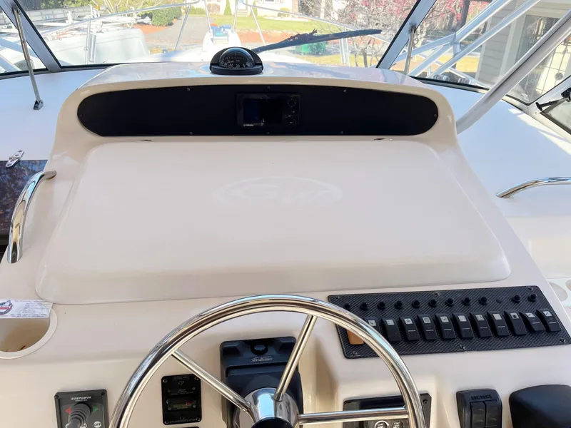 Slide: The Image of 2003 Grady-White 330 Express boat helm with steering wheel and control panel. - 7