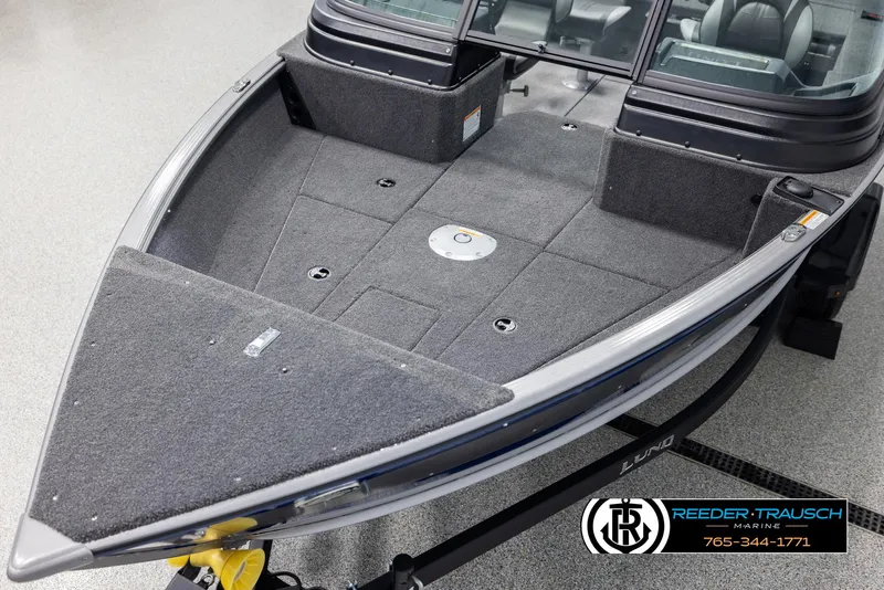 Slide: The Image of 2025 Lund 1775 Impact XS boat interior with carpeted deck and storage compartments. - 10
