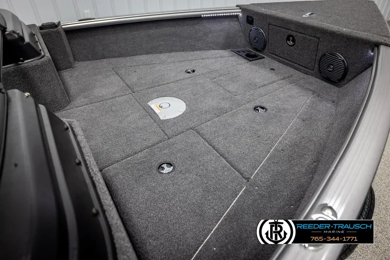 Slide: The Image of 2025 Lund 1775 Impact XS boat interior with carpeted deck and storage compartments. - 19