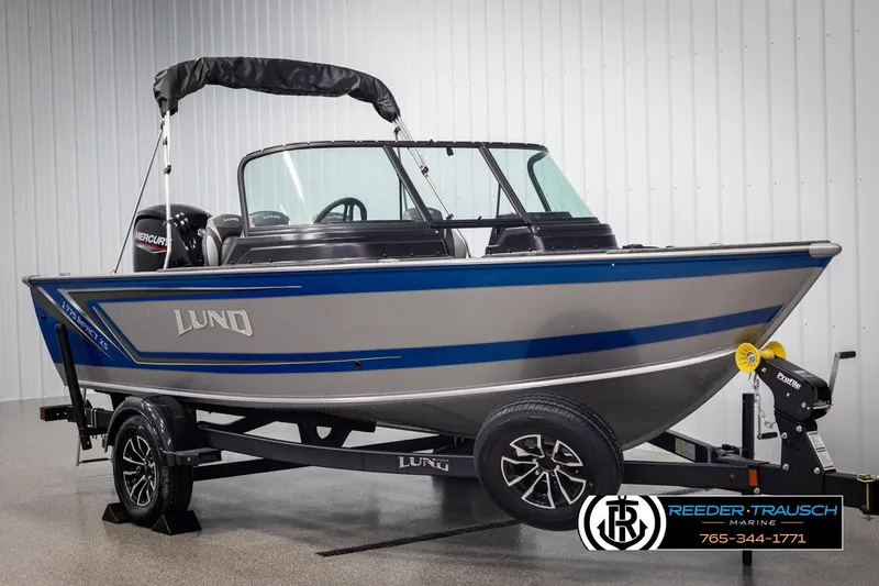 Slide: The Image of 2025 Lund 1775 Impact XS boat on trailer in showroom. - 2