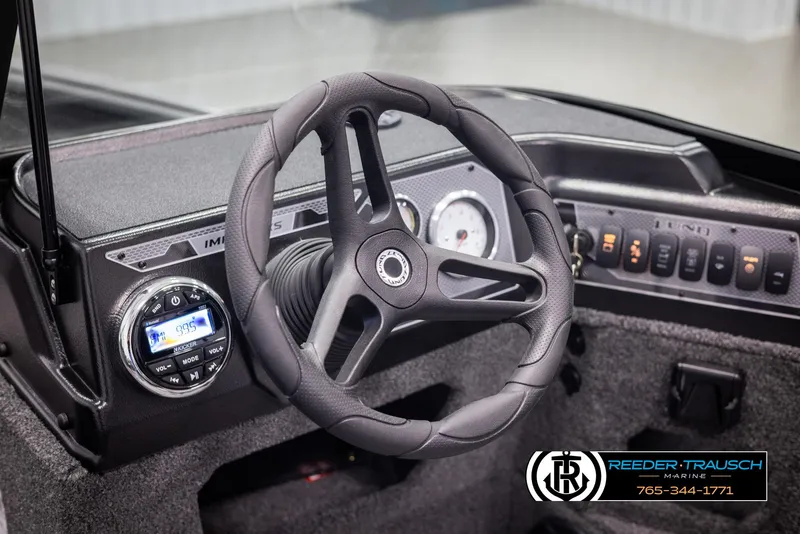 Slide: The Image of 2025 Lund 1775 Impact XS boat dashboard with steering wheel and control panel. - 25