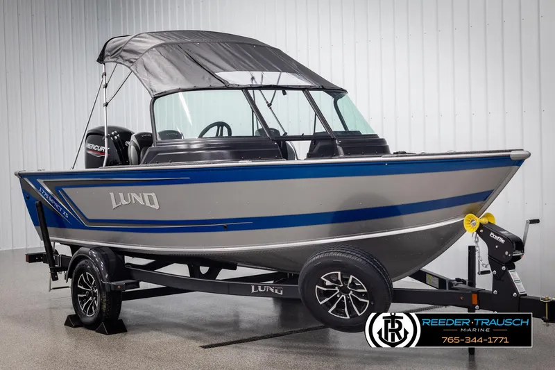 Slide: The Image of 2025 Lund 1775 Impact XS boat with canopy on trailer in showroom. - 3