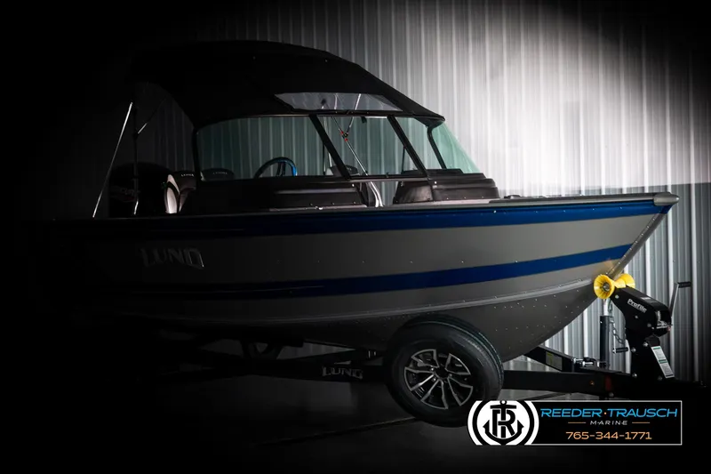 Slide: The Image of 2025 Lund 1775 Impact XS boat in a dimly lit showroom. - 4